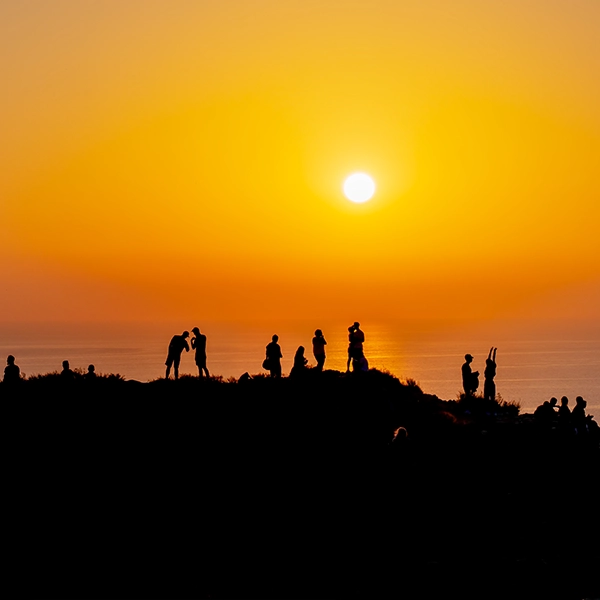Personas haciendo fotografías a una puesta de sol.